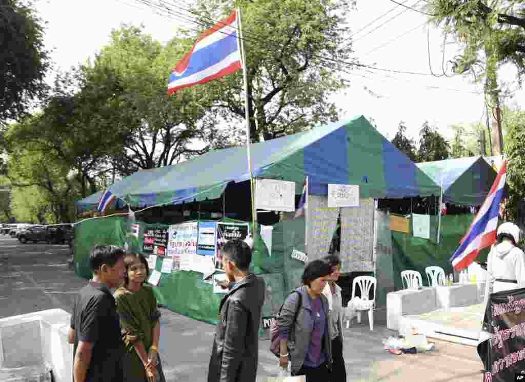 Thai anti-government protesters chat outside a makeshift camp where their colleagues were shot outside the prime minister&#39;s office of Government House in Bangkok, Thailand.