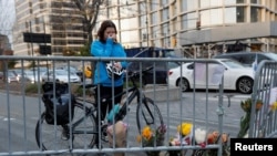 自行车骑士凯特·安斯泰特在纽约市西街自行车道上警察设置的路障旁的临时纪念地点擦拭眼泪。（2017年11月1日）