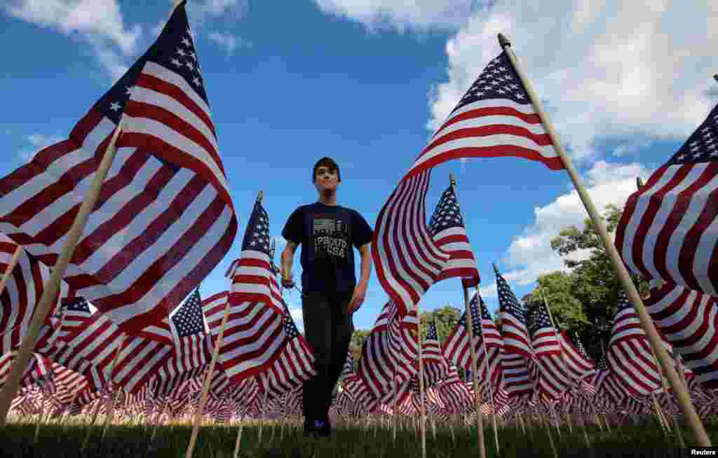 Jackson Tucker walks through the field of 3,000 U.S. flags placed in memory of the lives lost in the Sept. 11, 2001 attacks, at a park in Winnetka, Illinois, Sept. 10, 2016.