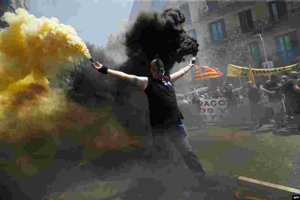A taxi driver holds flares as protesters gather outside the government delegation office during a strike by cab drivers in Barcelona.
