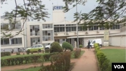 FILE - People walk by the entrance to the Yaoundé General Hospital in Yaoundé, March 6, 2020. 