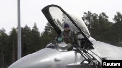 资料照片：2015年3月26日，在阿马里空军基地，美国空军第510战斗机中队一名飞行员正从F-16战斗机上下来。（路透社照片）