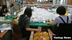 메르스 확산으로 마스크 수요가 급증하는 가운데 15일 경기 안양시 동안구에 위치한 안전보호구 전문업체 에버그린 직원들이 분주히 마스크를 만들고 있다. 