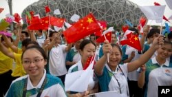 资料照：在北京奥林匹克体育场外，人们庆祝北京成功申办2022年冬季奥运会。（2015年7月31日）