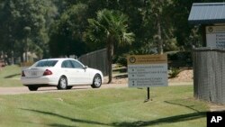 FILE - A car leaves the federal prison in Oakdale, La., Sept. 26, 2006. The federal Bureau of Prisons is locking up all its almost 150,000 inmates in their cells in an unparalleled effort to slow the spread of the coronavirus.