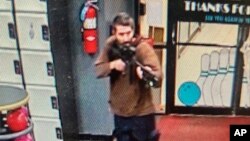 অ্যান্ড্রসকোগিন কাউন্টি শেরিফের কার্যালয় থেকে প্রকাশিত ভিডিও থেকে নেয়া এই ছবিতে এক বন্দুকধারী মেইনের লুইস্টনে স্পেয়ারটাইম রিক্রিয়েশানে প্রবেশ করছে। ২৫ অক্টোবর,২০২৩।