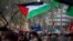 Seorang anak laki-laki mengibarkan bendera Palestina di tengah demonstrasi mendukung warga Palestina dan menyerukan gencatan senjata segera di Gaza, di Barcelona, Spanyol, 20 Januari 2024. (Foto: AP)