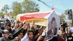 Para pelayat berpawai di Baghdad membawa peti berisi jenazah Mohammed Bdaiwi Owaid al-Shammari, pimpinan Radio Free Iraq biro Baghdad.
