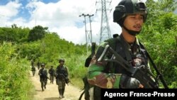 FILE - Military personnel arrive at Lembantongoa village in Palu, on Dec. 1, 2020, to track down Islamic State-linked extremists who killed four people in the remote Christian community on the Indonesian island of Sulawesi. 