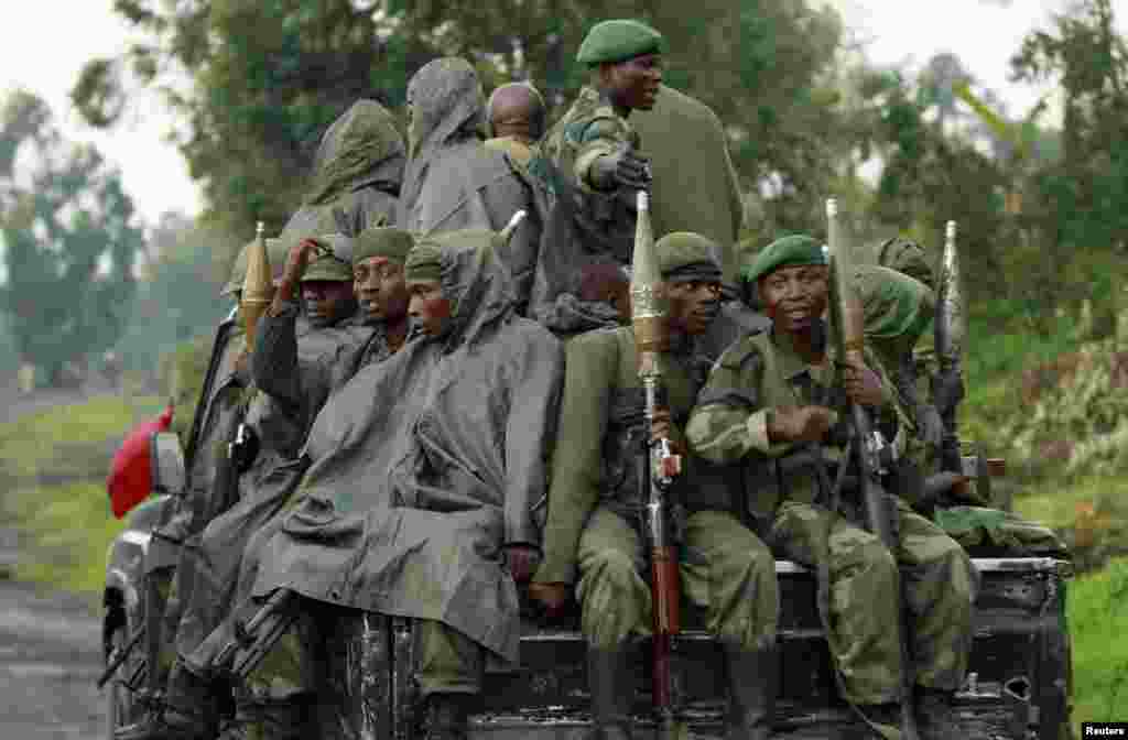 Congolese armed forces (FARDC) soldiers ride on their pick-up truck as they advance to a new position while battling M23 rebels in Kibati near Goma, in the eastern Democratic Republic of Congo.
