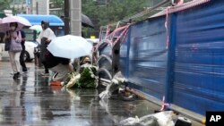 ແມ່ຍິງຄົນນຶ່ງ ວາງດອກໄມ້ຢູ່ສະຖານທີ່ເກີດອຸບັດຕິເຫດ ໃກ້ກັບຫ້ອງການເມືອງໃນນະຄອນຫຼວງໂຊລ, ເກົາຫຼີໃຕ້, ວັນອັງຄານ, ທີ 2 ກໍລະກົດ 2024.