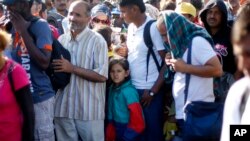 难民与移民在塞尔维亚与匈牙利边界线附近的一个移民中心等候大巴。 （2015年9月9日）