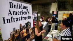 A recruiter talks with a job seeker at the Construction Careers Now! hiring event in Denver, Colorado, Aug. 2, 2017.