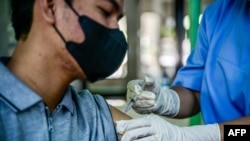 2023年12月19日，一名卫生工作者在雅加达省卫生办公室为一名男子接种 Covid-19 疫苗。（法新社照片）