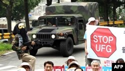 ԱՄՆ-ի հետ համատեղ զորավարժությունների դեմ բողոքի ցույց անցկացնող Հարվային Կորեայի բնակիչներ