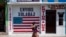 FILE - A closed business featuring a U.S. flag and the Spanish phrase "Send to U.S.A" is pictured in the largely indigenous town of Joyabaj, Guatemala, where half of the residents depend on remittances, almost all from the United States, April 3, 2020.