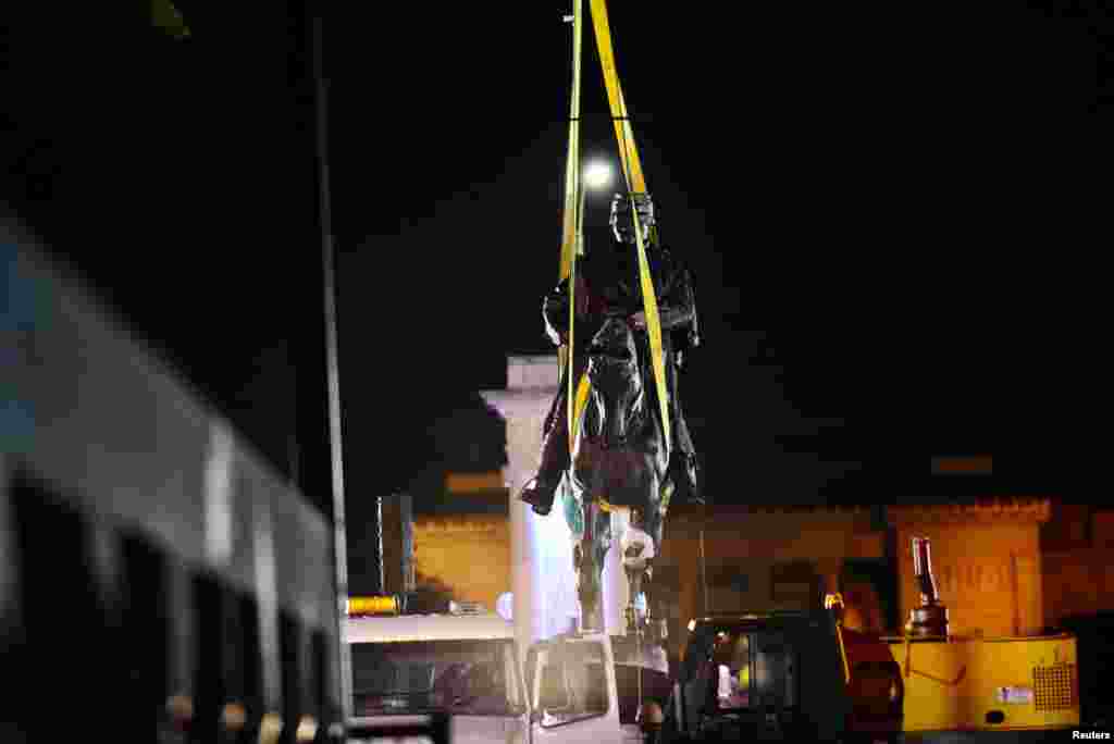 A construction crew works to remove a monument of Confederate General P.G.T. Beauregard at the entrance to City Park in New Orleans, Louisiana.