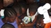 Girls in Sierra Leone read by the light of a single watt LED