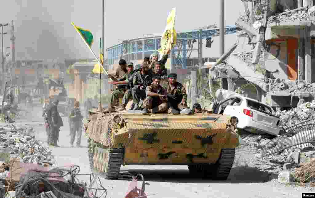 យុទ្ធជន​នៃ​កងកម្លាំង​ប្រជាធិបតេយ្យ​ស៊ីរី​ (SDF) កំពុង​ជិះ​រថក្រោះ​ក្នុង​ទីក្រុង​ Raqqa ខណ​ដែល​ពួកគេ​អបអរជ័យជម្នះ​និង​សេរី​ភាព​នៃទីក្រុង​នេះ​ពី​ការកាន់កាប់របស់​យុទ្ធជន​រដ្ឋឥស្លាម។