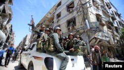 Policías sirios patrullan una calle de Duma, Siria, el 16 de abril.