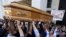 FILE - The body of Vittorio Casamonica is carried into a Roman Catholic basilica in a Rome suburb as a banner with his picture reads "You have conquered Rome, now conquer paradise" hangs to the entrance where the funeral was celebrated, Aug. 20, 2015.