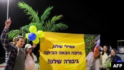 Des personnes brandissent une pancarte saluant Emily Damari, l'une des trois otages israéliens libérés qui avaient été enlevés lors des attaques du 7 octobre 2023 par des militants palestiniens. (Photo GIL COHEN-MAGEN / AFP)