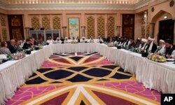 FILE - This photo released by Qatar's Ministry of Foreign Affairs shows Qatari, U.S. and Taliban officials conferring at an undisclosed location in Doha, Feb. 25, 2019.