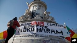 Wani dan kasar Kamaru a Faransa ke daga tuta dake cewa, kawunan 'yan Kamaru yazo daya dangane da yaki da Boko Haram. 