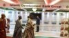 FILE - Traditional chiefs walk past an Islamic Development Bank Group stand during a meeting of the Ministers of Foreign Affairs of the Organization of Islamic Cooperation (OIC) in Abidjan, July 10, 2017.
