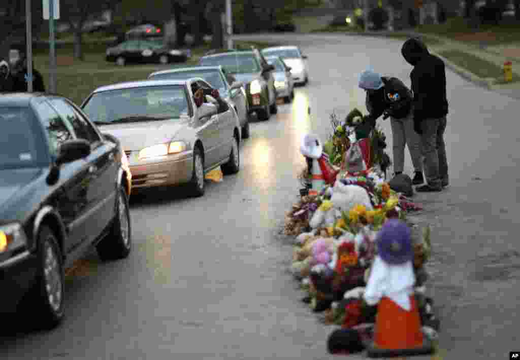 Para demonstran berkumpul dekat memorial di tengah jalan (24/11) di Ferguson, Missouri.
