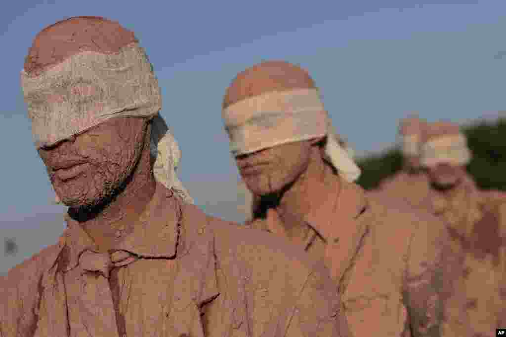 Para seniman dari kelompok Deviation Collective yang berasal dari Sao Paulo mengambil bagian dalam sebuah pertunjukan yang disebut &ldquo;Cegos&rdquo; atau Buta, di depan Istana Kepresidenan Planalto, di Brasilia, Brazil (25/8).&nbsp; &ldquo;Cegos&rdquo; didefinisikan oleh kelompok tersebut sebagai sebuah karya terbuka dari interpretasi yang berbeda-beda; &ldquo;mengecilkan eksistensi kami menjadi fungsi produktif dan konsumtif, dibebani pekerjaan, pemenjaraan, dan pembekuan kehidupan.&rdquo;