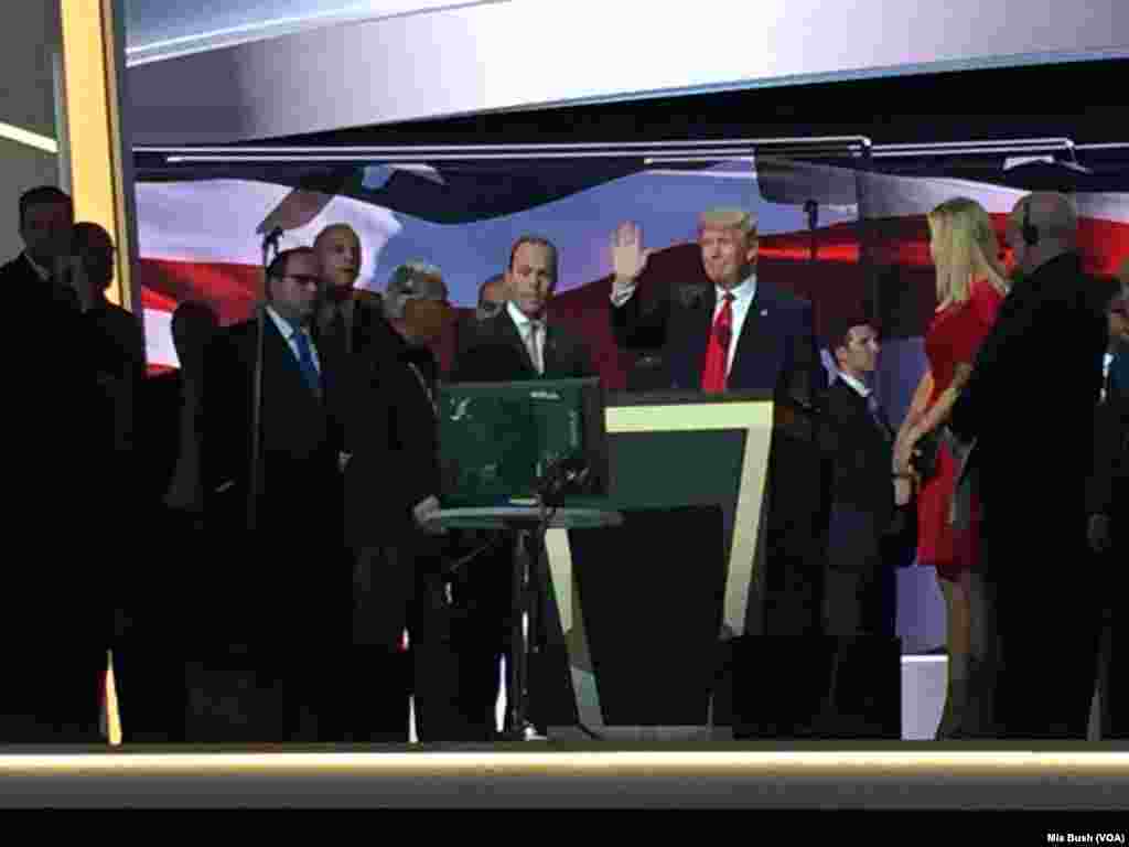 Republican presidential nominee Donald Trump waves to the media as he prepares to do a soundcheck from the stage, where a new podium was put in place early Thursday, at the Republican National Convention, in Cleveland, July 21, 2016.