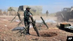 FILE - In this photo released by the Syrian official news agency SANA, Syrian army soldiers prepare to launch a mortar towards insurgents in the village of Kfar Nabuda, in the countryside of Hama province, Syria, May 11, 2019.