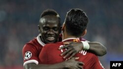 Liverpool's Brazilian midfielder Roberto Firmino (R) celebrates with Liverpool's Senegalese midfielder Madio Sane face au FC Seville au stade Ramon Sanchez Pizjuan, Espagne, le 21 novembre 2017