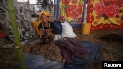 一名因最近若开邦的宗派暴力离乡背井的妇女与她的孩子11月1日在难民营里