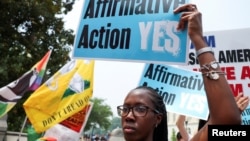 资料照片：美国首都华盛顿，一名妇女举着标语，支持和反对美国最高法院驳回哈佛大学和北卡罗来纳大学考虑种族因素的学生录取计划的示威者在对峙。（2023年6月29日）