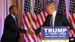 Poignée de main entre Ben Carson, ex-candidat aux primaires républicaines et Donald Trump, lors d'une conférence de presse à Palm Beach, en Floride, vendredi 11 mars 2016. (AP Photo/Lynne Sladky)