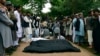 Victims' bodies are placed on the ground after heavy flooding in Baghlan province in northern Afghanistan on May 11, 2024.