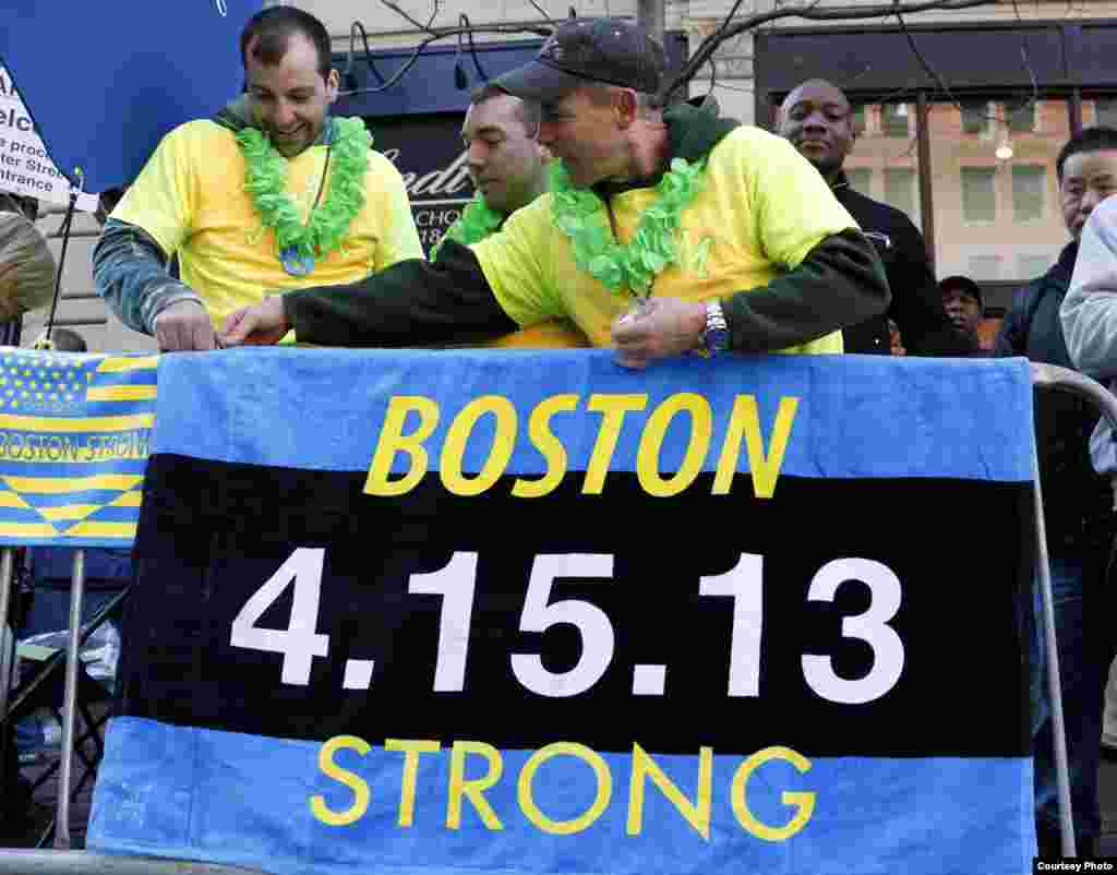 2014年4月21日，在波士顿马拉松开始前，人们把上面写着&quot;波士顿强大&quot;的旗帜挂起来。(今日美国报记者格莱格.库柏拍摄)