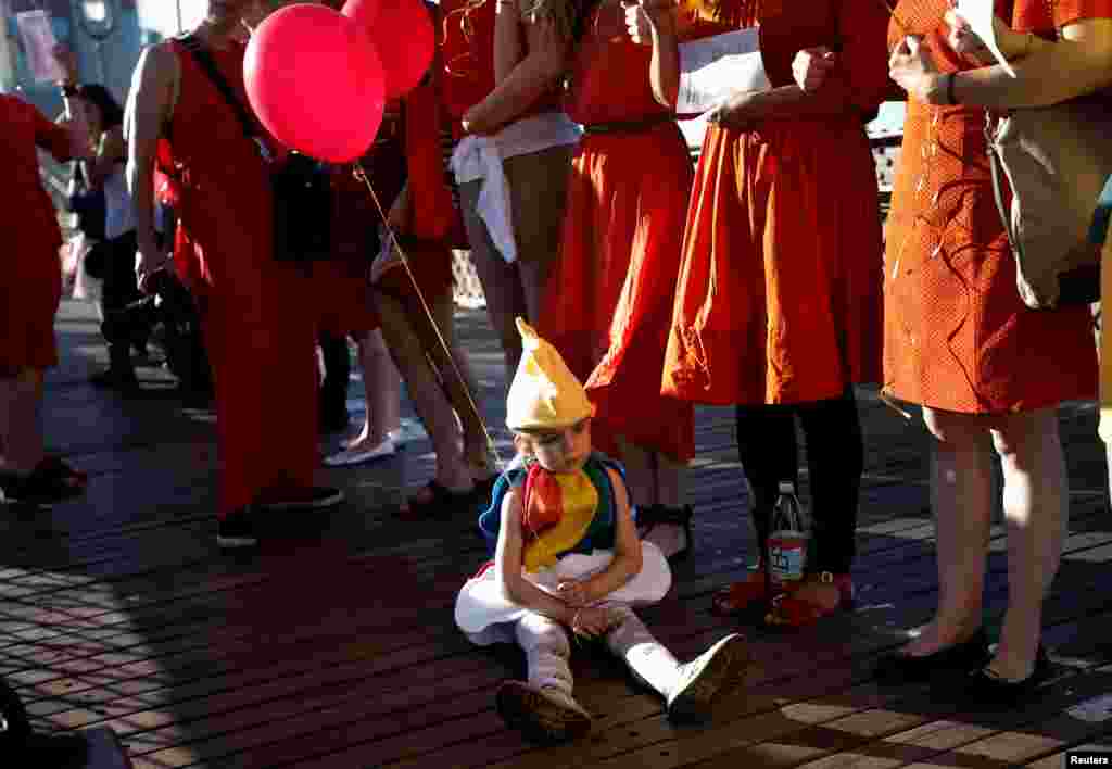 កុមារា​អាយុ​បួនឆ្នាំ Izzy Rogers អង្គុយ​នៅ​ក្នុង​ចំណោម​មនុស្សម្នា​កាន់​ប៉េងប៉ោង​លើ​ស្ពាន Brooklyn Bridge ក្រុង​ញូវយ៉ក សហរដ្ឋអាមេរិក កាល​ពី​ថ្ងៃទី១៤ ខែ​មិថុនា ឆ្នាំ​២០១៦ នៅ​ស្របពេលដែល​មនុស្សម្នា​បាន​តម្រង់​ជួរ​ដើម្បី​បង្កើត​ជា &laquo;មនុស្ស​ឥន្ទនូ&raquo; អំឡុងពេល​ការ​ប្រមូលផ្តុំ​គ្នា​ដើម្បី​រំឮក​ដល់​ជនរងគ្រោះ​ពី​ការ​បាញ់​ប្រហារ​នៅ​ក្រុង​ Orlando។