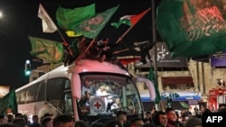 一辆红十字会巴士载着根据停火协议被以色列释放的一批巴勒斯坦囚犯。（法新社2023年11月26日）