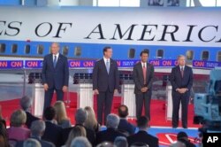 Republican presidential candidates, former New York Gov. George Pataki, left, former Pennsylvania Sen. Rick Santorum, second from left, Louisiana Gov. Bobby Jindal, second from right, and Sen. Lindsey Graham, R-S.C., take the stage in the early CNN Republican debate.