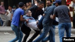 16일 이집트 카이로 람세스 광장에서 무르시 지지 시위 도중 다시 유혈 충돌이 벌어진 가운데, 시위대가 부상자를 옮기고 있다.