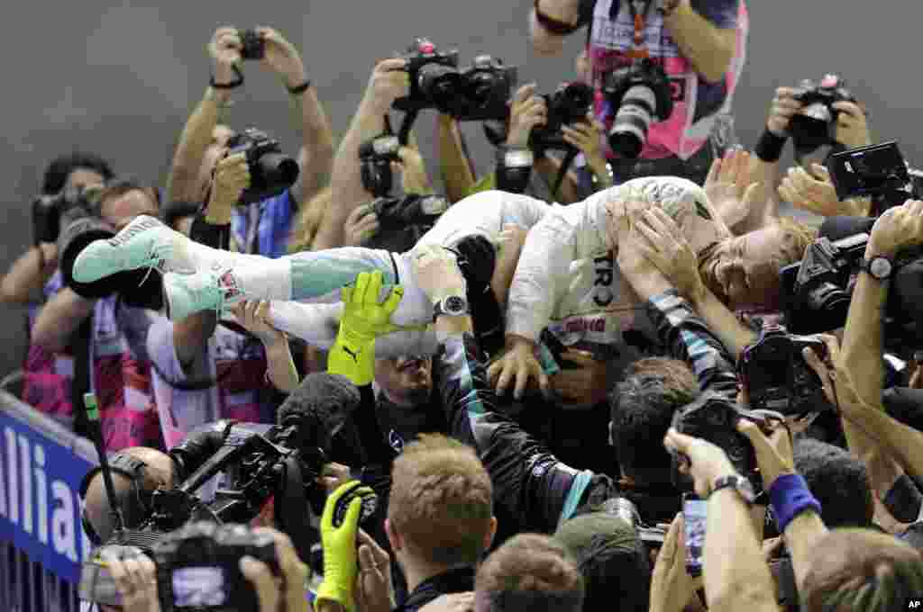 Mercedes driver Nico Rosberg of Germany is embraced by his team after winning the Singapore Formula One Grand Prix on the Marina Bay City Circuit Singapore.