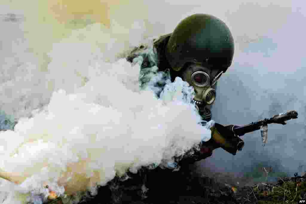 A serviceman of Belarus&#39; Interior Ministry&#39;s special forces unit takes part in the qualifying examinations for the &quot;Madder Beret&quot; headdress outside Minsk.