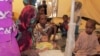 FILE - A family of refugees from the Central African Republic sit under a tent with their newborn baby at a camp in the eastern Cameroonian city of Garoua-Boulai.