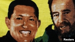 Para pendukung Presiden Venezuela Hugo Chavez (tidak nampak pada gambar) menggenggam spanduk bergambar Chaves bersama mantan pemimpin Kuba Fidel Castro (kanan) dalam persiapan pelantikan di Caracas, 5 January 2013 (Foto: dok). 
