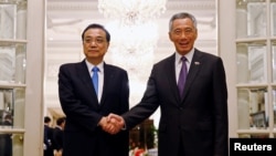 新加坡总理李显龙在新加坡总统府与中国总理李克强握手。（2018年11月12日）