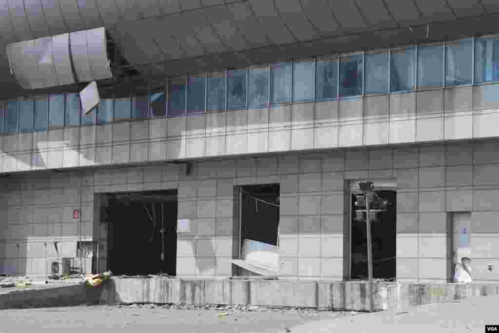 天津爆炸事故现场，核心爆炸区周围多座居民楼窗户被震碎，高速公路桥梁受损，多辆大货车被炸翻，小汽车起火或被砸，多名当地居民仍逗留在事故现场。（美国之音记者东方拍摄）