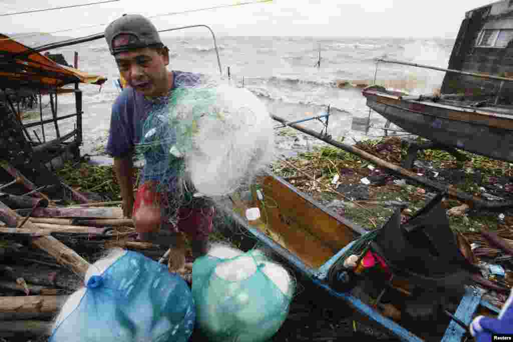 A fisherman carries his net after making it safely back to shore in the fishing village after a strong winds from Typhoon Haiyan battered Bayog town in Los Banos, Laguna city, south of Manila, Nov. 8, 2013.&nbsp;